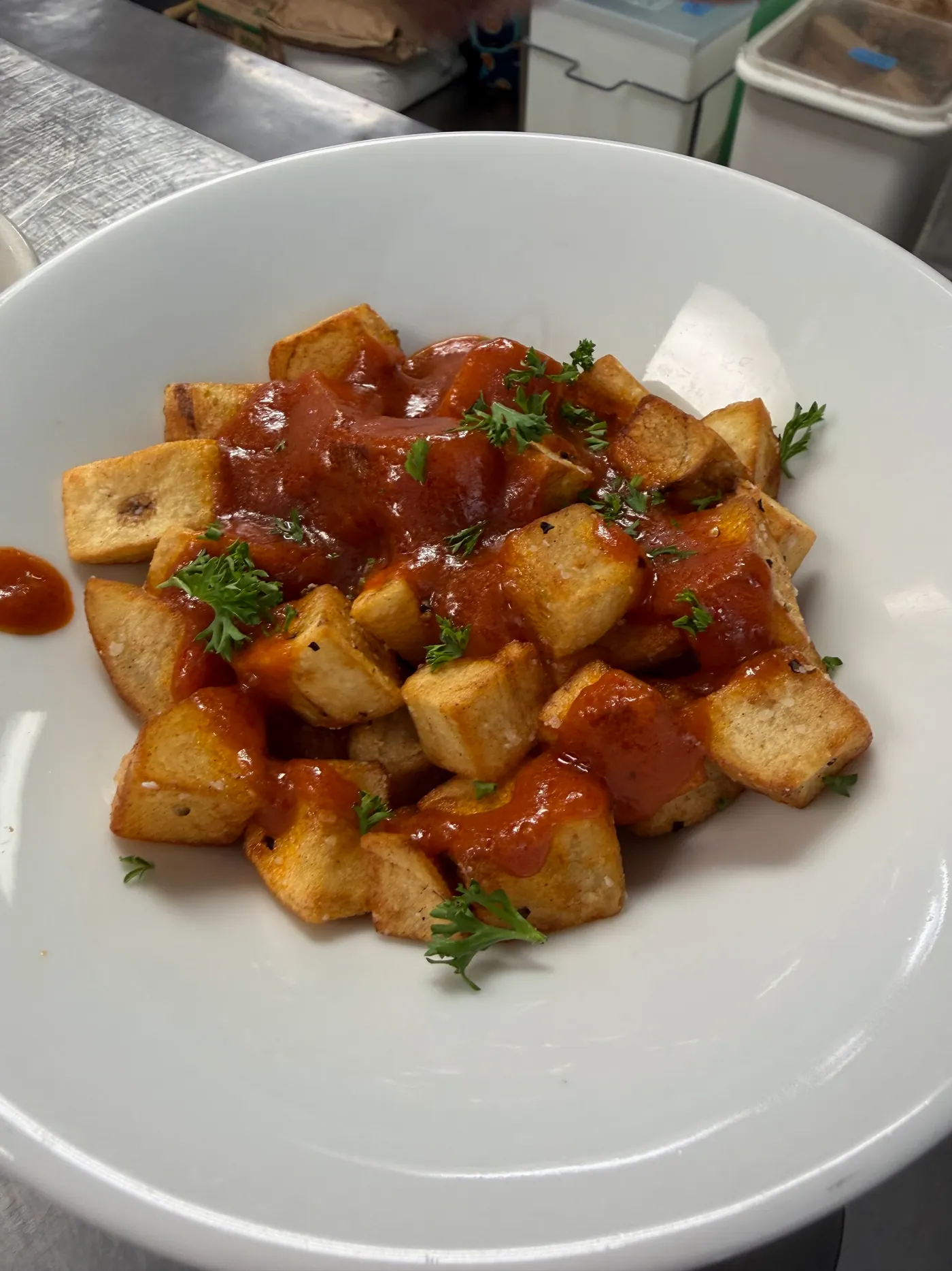 Crispy potato cubes with a red brava sauce and parsley