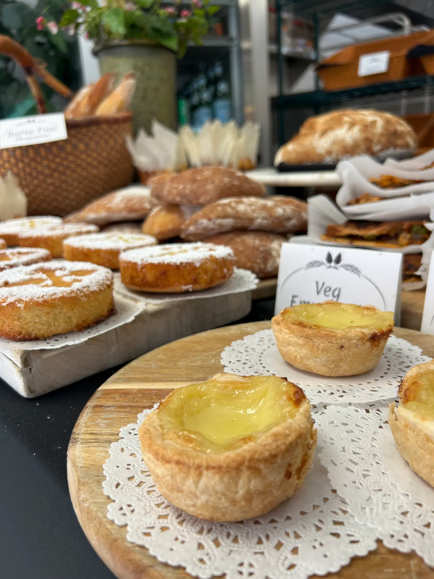 Custard tarts, empanadas and loaves in the bakery case